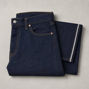 Indigo jeans folded, showing the waistband and selvedge edge