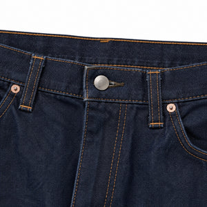 Waistband, button fly and copper rivet on the indigo jeans