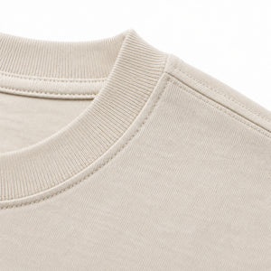 Ribbed collar and shoulder seam of the ecru t-shirt
